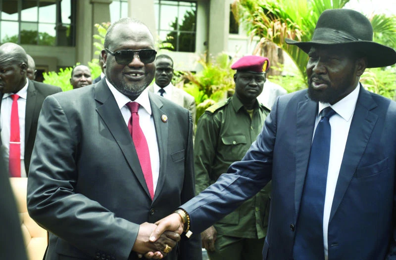 POWER POLITICS: South Sudan’s first Vice President Riek Machar, left, and President Salva Kiir, right, shake hands following the meeting of a new coalition government, in Juba, on Friday. (AP)