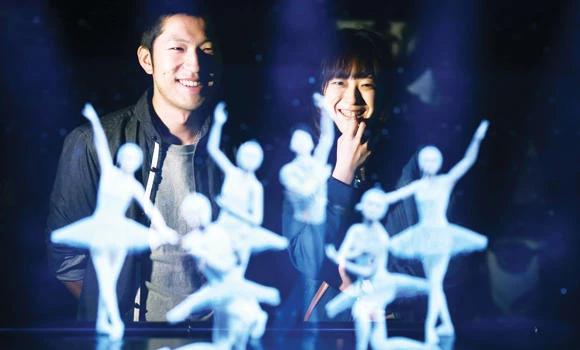 CELEBRITY DANCE: Tomoaki Ishizuka, left, and Yurika Yonekura, right, watch the hologram of Japanese skater Yuzuru Hanyu, center, with ballet dancers with their scanned faces attached at newly opened Hologram Dance Theater at Madame Tussauds in Tokyo, on Thursday. (AP)