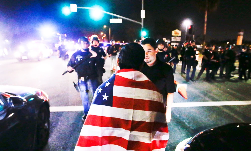Protestors are pushed off the street by law enforcement after a rally for Republican presidential candidate Donald Trump, Thursday, April 28, 2016 in Costa Mesa, Calif. (AP)
