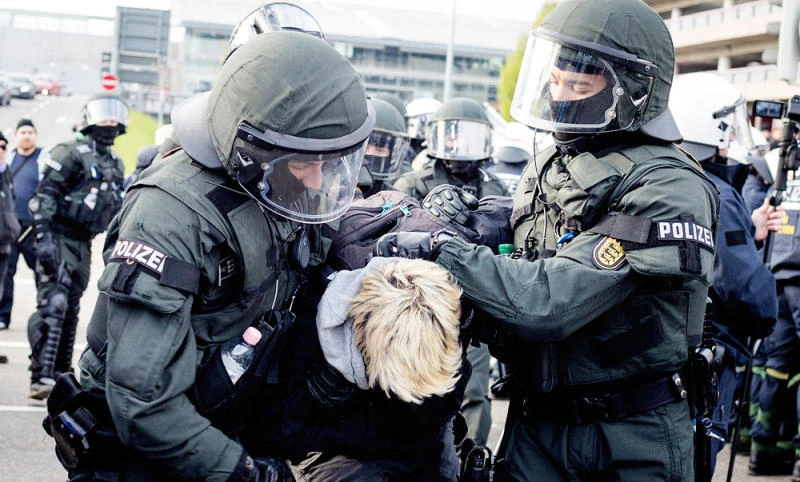 Police detain a leftist demonstrator on the occasion of a party convention of the Alternative for Germany, or AfD, in Stuttgart, Germany Saturday, April 30, 2016. (Christoph Schmidt/dpa via AP)