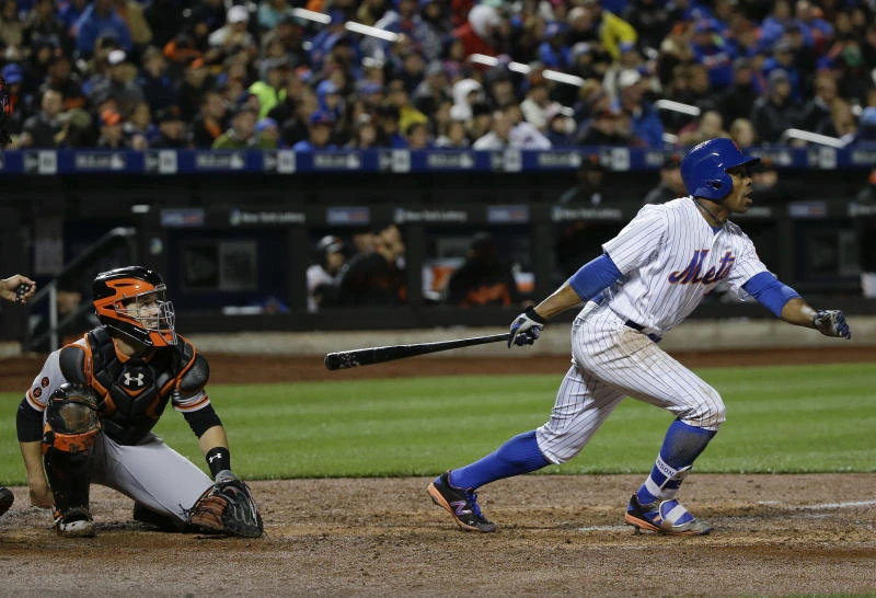 BIG WIN: New York Mets' Curtis Granderson, right, follows through on a base hit to right field as San Francisco Giants catcher Buster Posey, left, looks on during the third inning of a baseball game in New York on Friday. (AP)