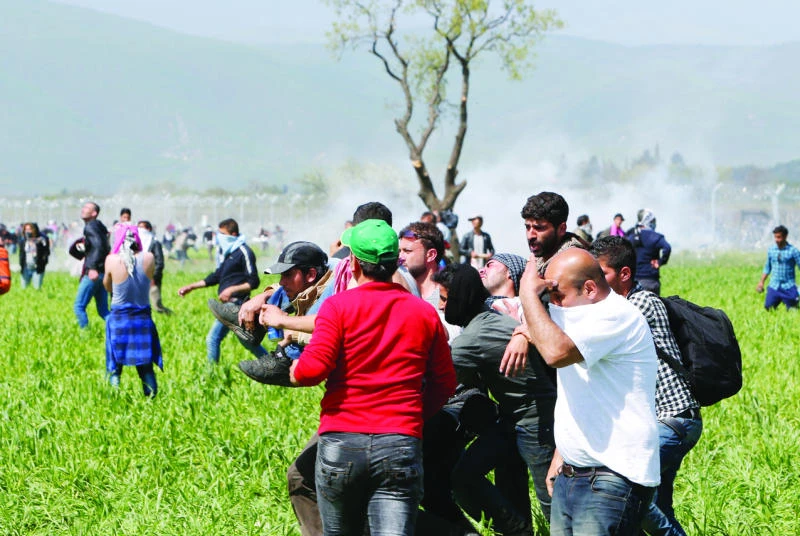 Police tear-gas migrants on border; dozens hurt