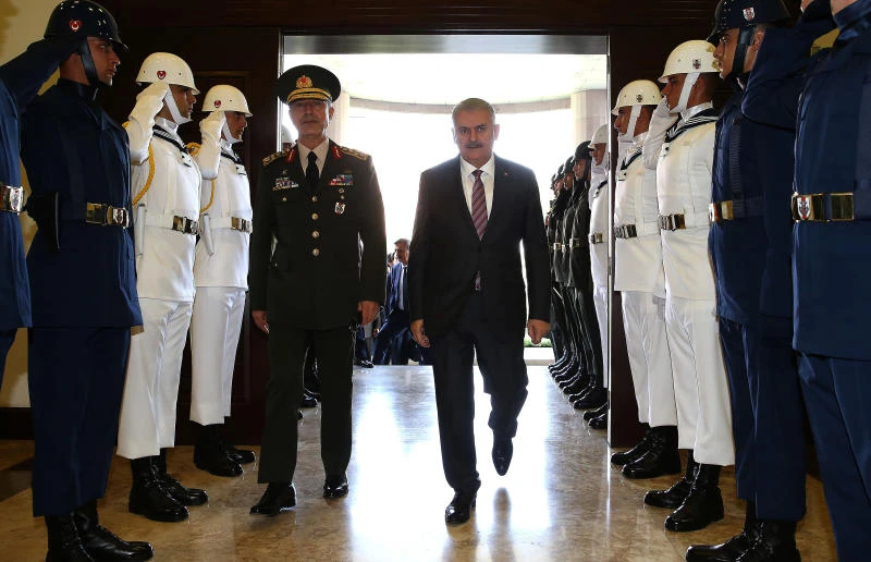 Turkey's Prime Minister Binali Yildirim, right, and the Turkey's Chief of Staff Geneneral Hulusi Akar review a honor guard before their meeting at the military headquarters in Ankara, Turkey. (Hakan Goktepe/Pool Photo via AP)