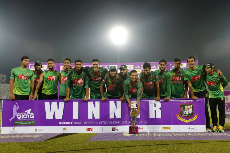 TRIUMPHANT: Bangladesh players pose with the trophy after winning their series against Afghanistan in Dhaka Saturday. (AP)