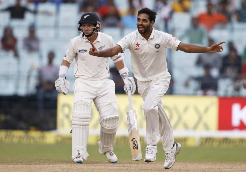 ONE DOWN: Indian bowler Bhuvneshwar Kumar, right, celebrates after taking the wicket of New Zealand's Matt Henry on the second day of the second cricket Test match in Kolkata Saturday. (AP)
