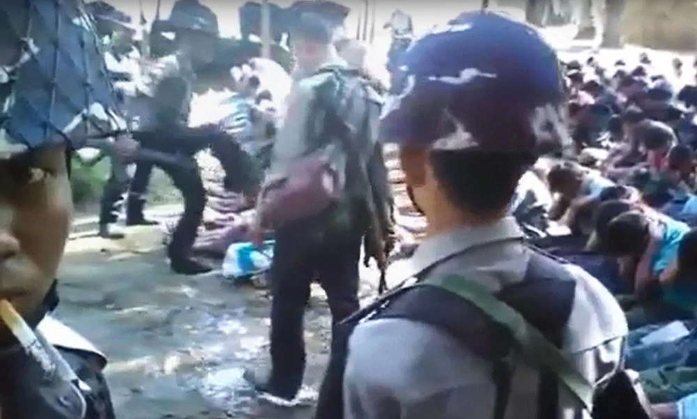 This screen grab taken on Jan. 4, 2017 from a YouTube video originally taken by Myanmar Constable Zaw Myo Htike (pictured at far L - looking at camera) shows a policeman kicking out at a Rohingya minority villager seated on the ground with others, in the village of Kotankauk during a police area clearance operation on November 5, 2016. (AFP)