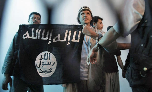 In this April 23, 2013 file photo, a defiant Yemeni Al-Qaida militant, center, holds a banner during a court hearing in state security court in Sanaa, Yemen. A top leader of Yemen's Al-Qaida branch has been killed in a US air strike, the Pentagon said on Friday. (AP file photo)