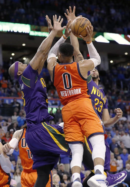 Oklahoma City Thunder guard Russell Westbrook, center, is blocked by New Orleans Pelicans forward Dante Cunningham, left, and New Orleans Pelicans forward Anthony Davis, right, on the way to the basket during the second half of an NBA basketball game in Oklahoma City Sunday. Oklahoma City won 118-110. (AP)
