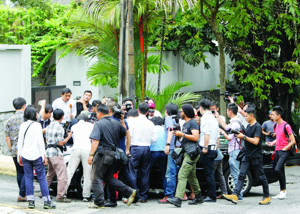 Journalists gather around a car leaving North Korean Embassy in Kuala Lumpur on Monday. (AP)