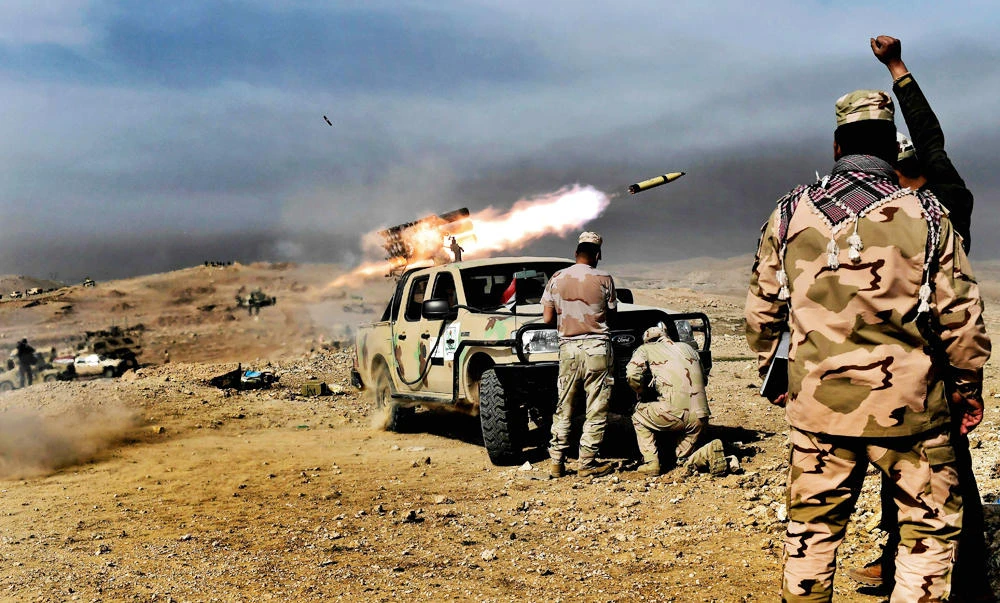 Members of the Iraqi army's 9th Division fire a multiple rocket launcher from a hill in Talul al-Atshana, on the southwestern outskirts of Mosul, on Monday, during an offensive to retake the city from Islamic State (IS) group fighters. (AFP)