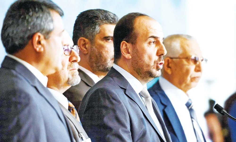 Syria’s main opposition leader Nasr Al-Hariri, second right, speaks to reporters after a meeting with the UN special envoy during Syria peace talks on Monday in Geneva. (AFP)