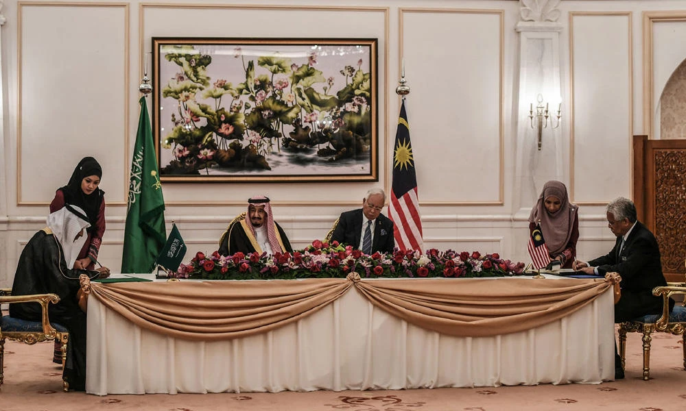 Malaysia's Minister of Higher Education Idris Jusoh (R) and Saudi Arabia's Minister of Labour and Social Development Ali Nassir Al Ghafies (L) sign documents as Saudi King Sultan Salman Abdulaziz and Malaysia's Prime Minister Najib Razak look on during the signing of a memorandum of understanding between the two countries in Putrajaya, outside Kuala Lumpur on February 27, 2017. (AFP / MOHD RASFAN)
