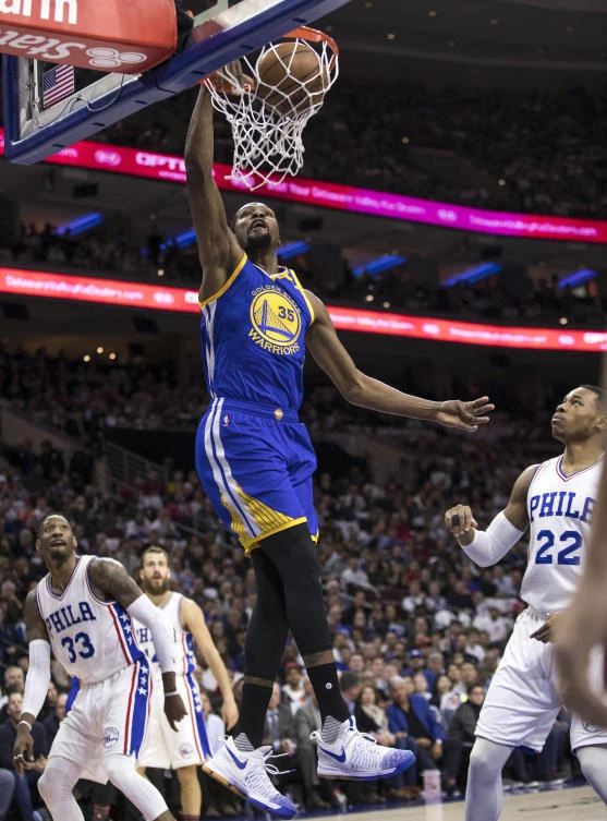 Golden State Warriors' Kevin Durant, center, goes up for the dunk during the first half of an NBA basketball game against the Philadelphia 76ers on Monday. (AP)