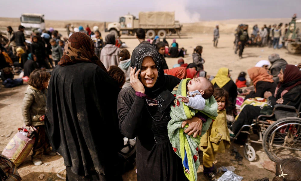 A displaced Iraqi woman who just fled her home talks on the phone as Iraqi forces battle with Daesh militants, in western Mosul, Iraq, on Monday. (REUTERS/Zohra Bensemra)