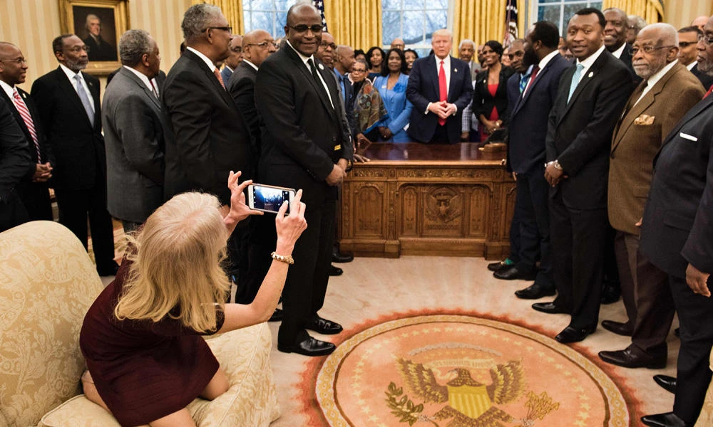 Counselor to the President Kellyanne Conway takes a photo as US President Donald Trump and leaders of historically black universities and colleges talk before a group photo in the Oval Office of the White House before a meeting with US Vice President Mike Pence on Monday in Washington, DC. (AFP / Brendan Smialowski)