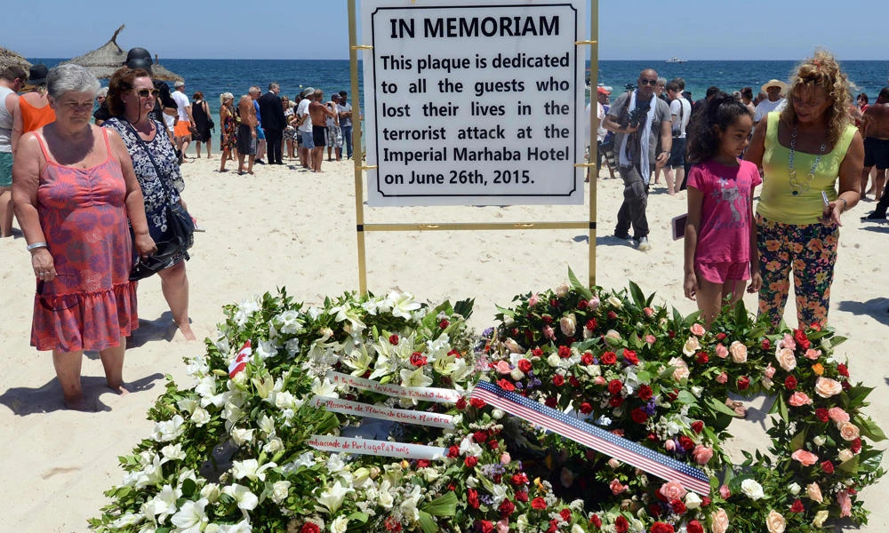 This file photo taken on July 03, 2015 shows tourists and Tunisians taking part in a ceremony on July 3, 2015, in memory of those killed the previous week by a jihadist gunman in front of the Riu Imperial Marhaba Hotel in Port el Kantaoui, on the outskirts of Sousse south of the capital Tunis. (AFP / Fethi Belaid)