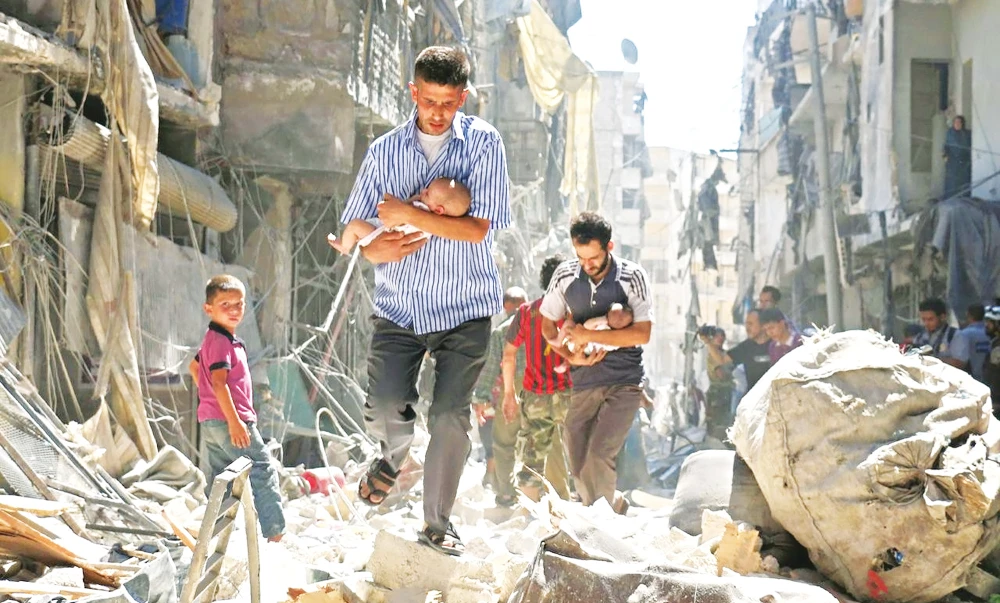 Syrians carrying babies make their way through the rubble of destroyed buildings following a regime airstrike in Aleppo on Sept. 11, 2016. (AFP)
