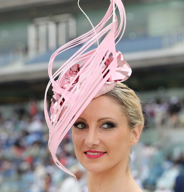 A guest wearing a hat arrives at the Meydan Racecourse to attend the Dubai World Cup day horse racing event , Dubai. (AFP)