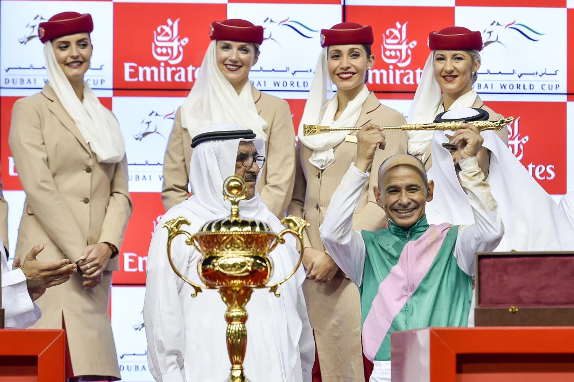 celebrates with the Deputy Ruler of Dubai, Sheikh Hamdan bin Rashid Al Maktoum, as he holds the golden whip after winning the U.S. $ 10,000,000 Dubai World Cup horse racing at the Meydan Racecourse in Dubai. (AP)
