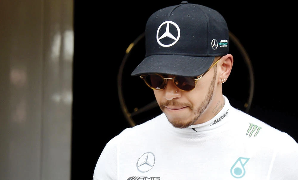 Mercedes AMG Petronas F1 Team's British driver Lewis Hamilton walks at the Circuit de Catalunya on Tuesday in Montmelo on the outskirts of Barcelona during the second day of the first week of tests for the Formula One Grand Prix season. (AFP)