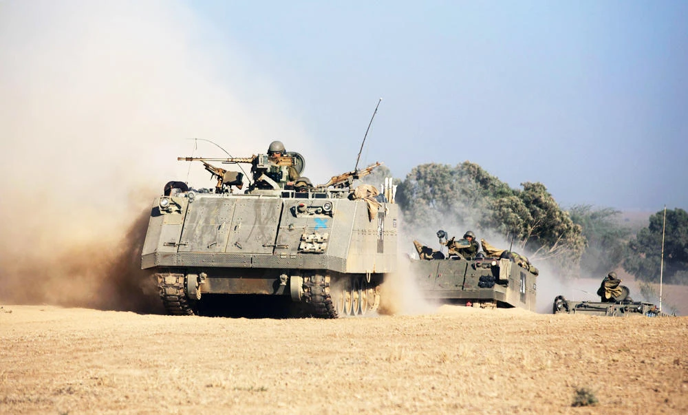 This file photo taken on July 20, 2014 shows a convoy of Israeli armoured personnel carrier (APC) rolling towards the Israeli-Gaza border in an army deployment area on July 20, 2014. (AFP)