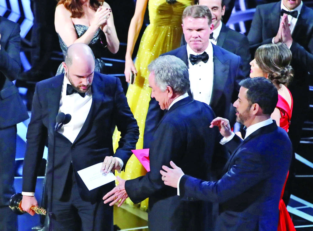 Brian Cullinan, upper right, of PricewaterhouseCoopers confers on stage after best picture was mistakenly awarded to “La La Land” instead of “Moonlight”. “La La Land” producer Jordan Horowitz, left, holds the correct envelope for best picture. (Reuters)