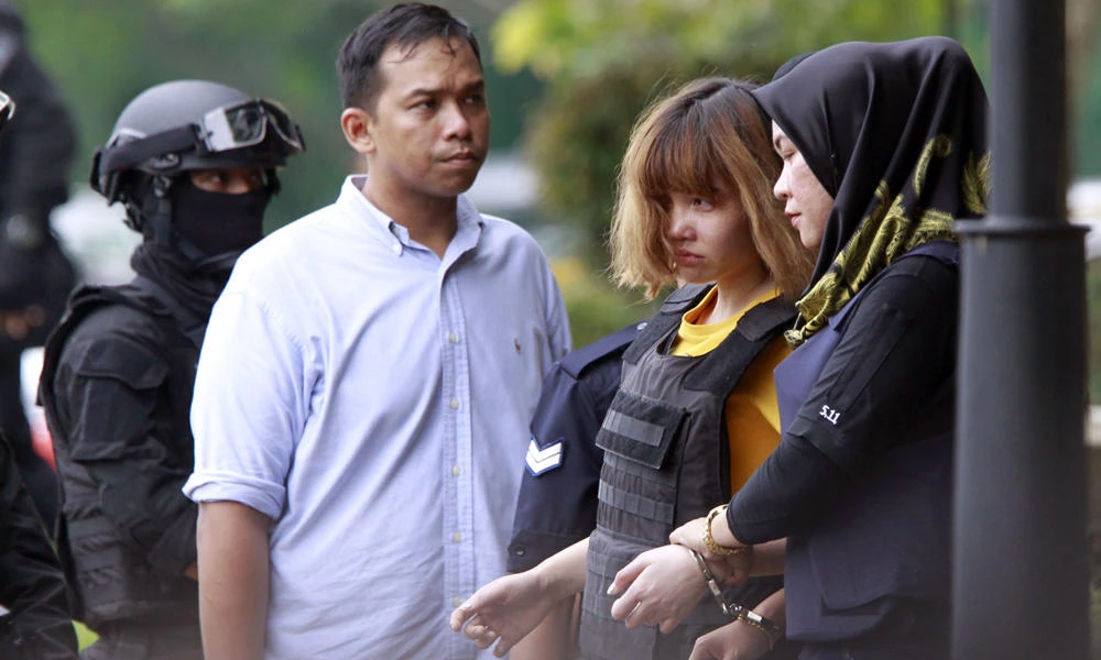 Vietnamese Doan Thi Huong (2nd from right), a suspect in the ongoing assassination investigation, is escorted by police officers out from Sepang court in Malaysia on Wednesday. Huong and a Malaysian woman are accused of smearing VX nerve agent on Kim Jong Nam, the estranged half brother of North Korea's leader. (AP Photo/Daniel Chan)