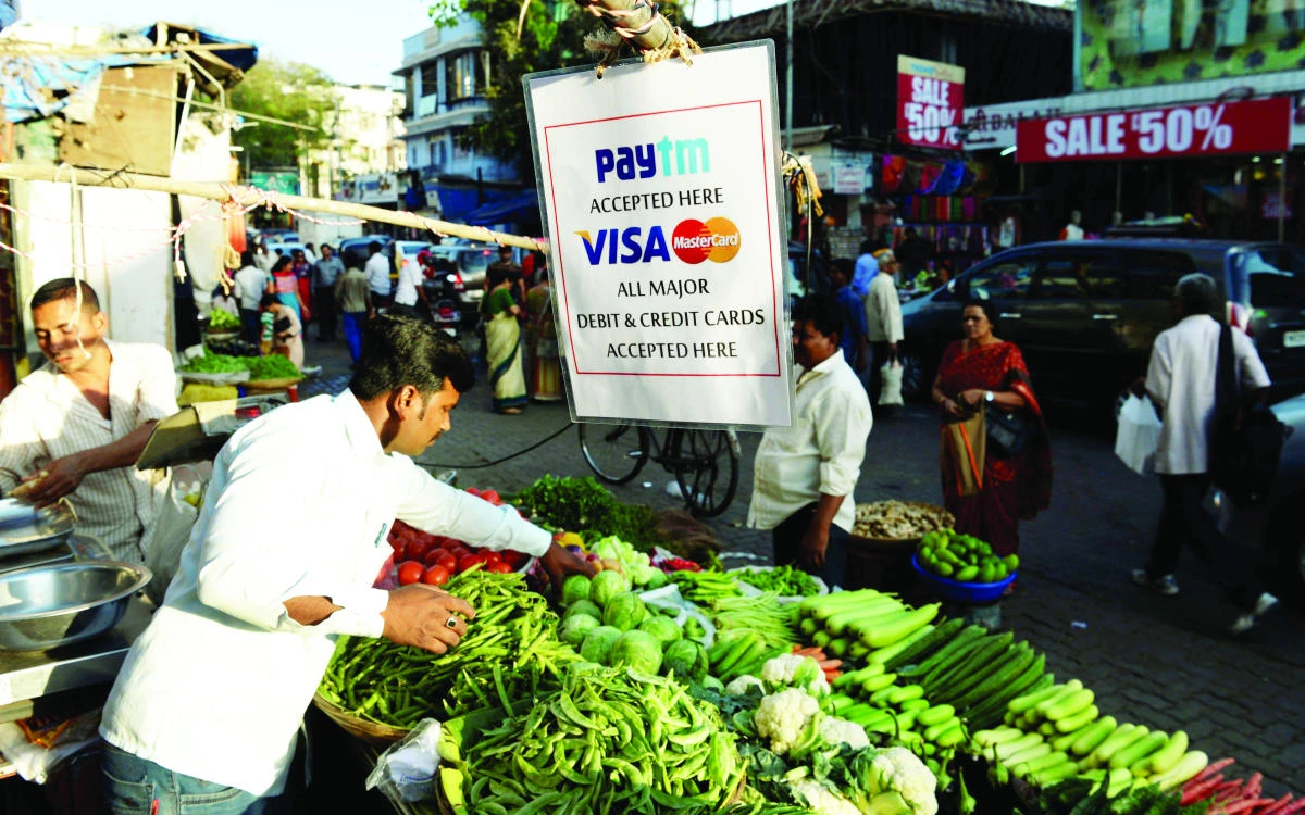 A sign advertising Indian electronic and cellphone-based payment system Paytm hangs at a roadside vegetable stall in Mumbai. (AFP)