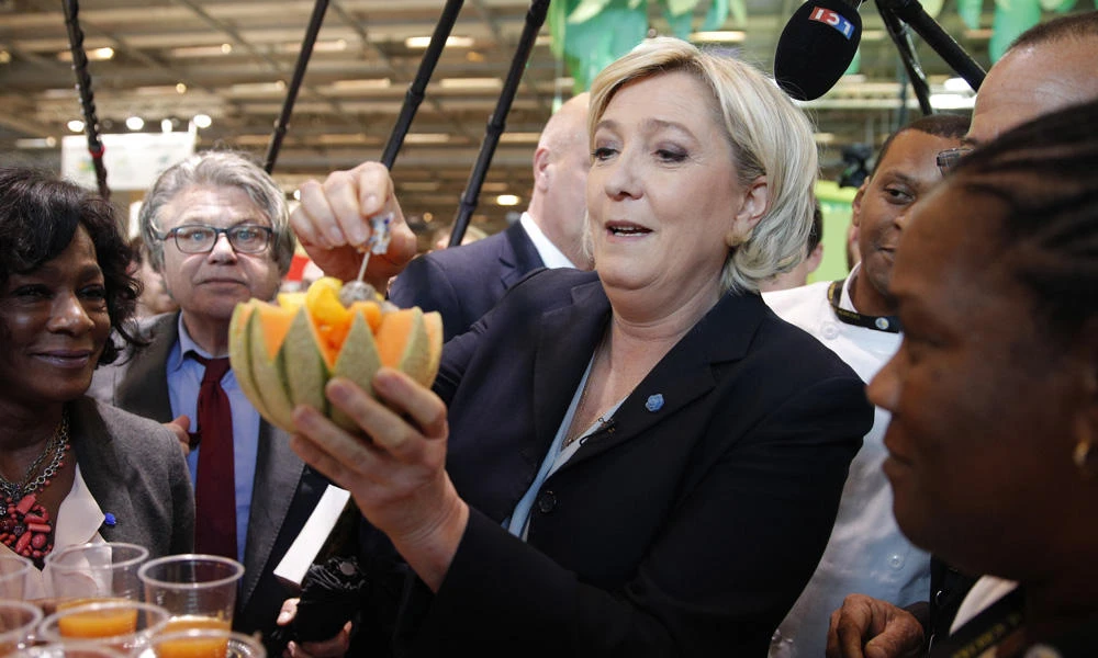 French far-right leader Marine le Pen holds a melon at the French Caraibean islands stand as she visits the Agriculture Fair on Tuesday in Paris.(AP Photo/Christophe Ena)