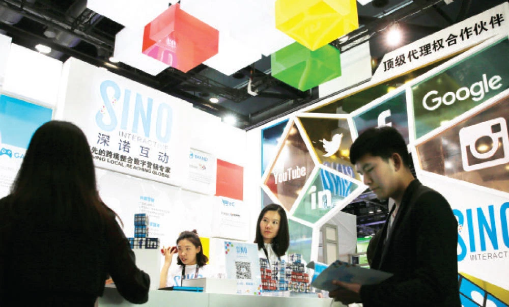 A visitor browses a booklet at a social network company booth, which enable people to connect global clients during the 2016 Global Mobile Internet Conference in Beijing in this April 28, 2016 file photo. (AP)