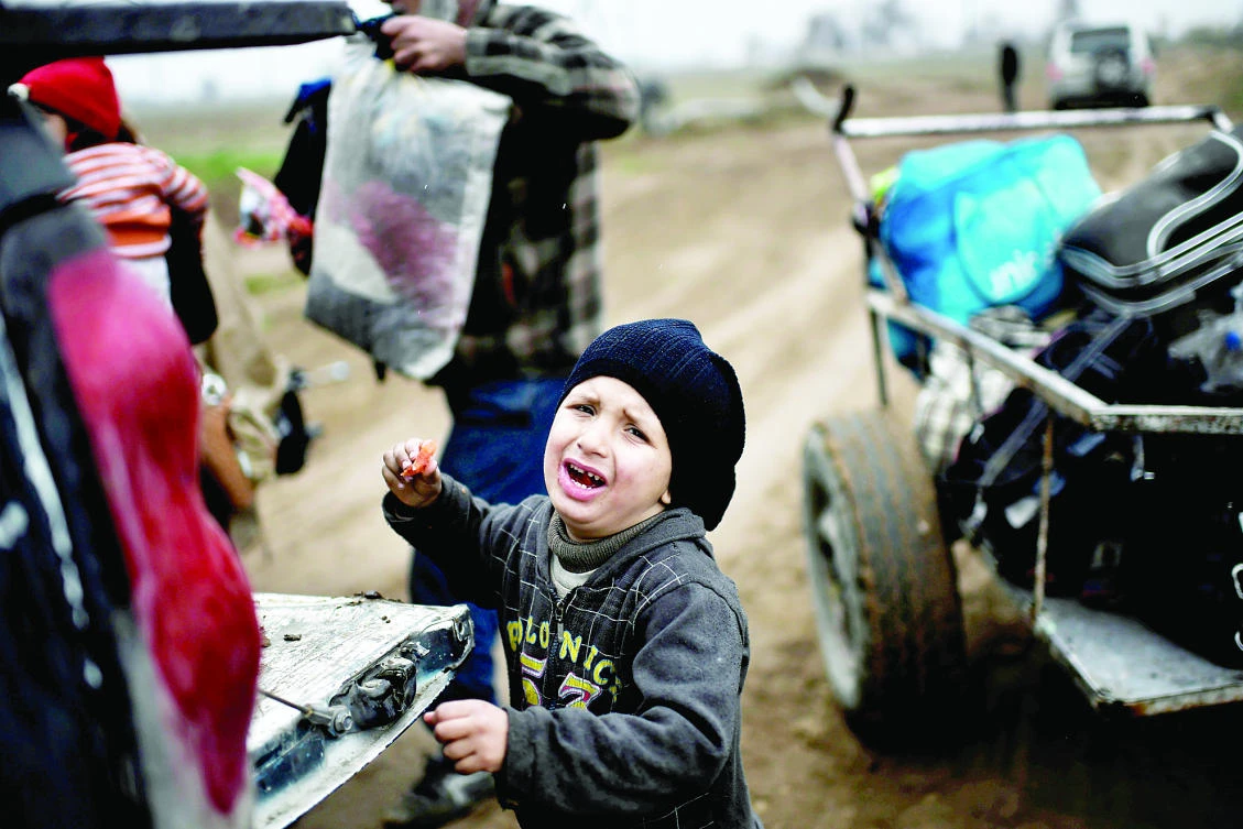 Displaced residents of Mosul evacuate the city on Thursday during an offensive by security forces to retake the western parts of the city from Daesh group. (AFP)