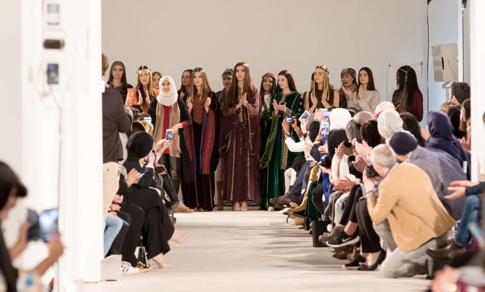 An appreciative audience applauds designers.