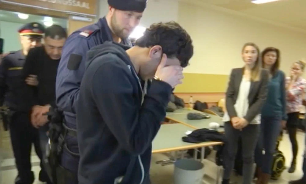 A defendant covers his face as he is lead out of the court room after his trial on gang-raping a German tourist in Vienna, Austria. (AP)
