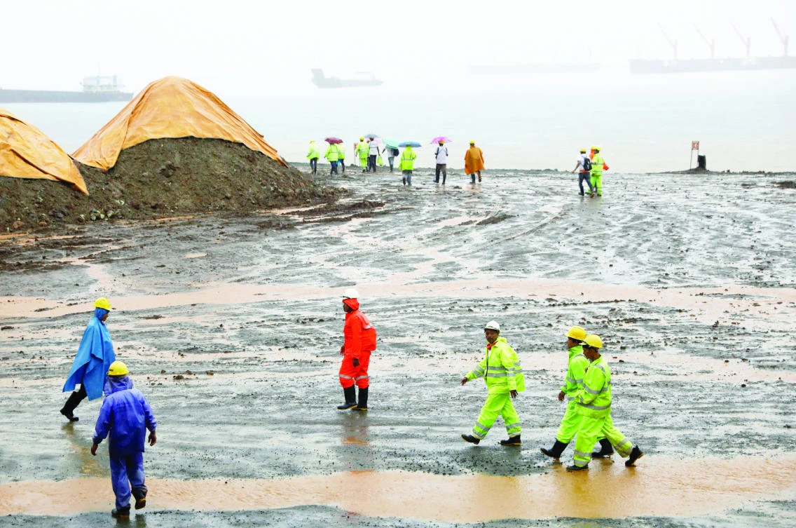 Workers walk at the port of an active nickel-ore mine SR Metals in Tubay, Agusan del Sur in southern Philippines. (Reuters)