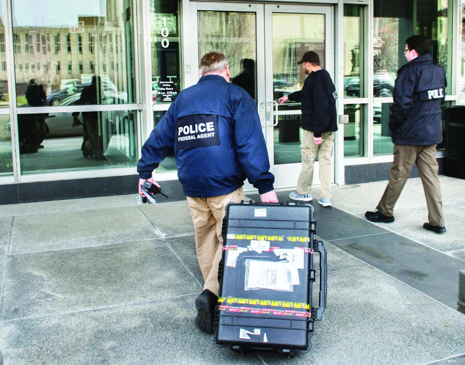 Federal law enforcement agents enter the headquarters of Caterpillar in Peoria, Ill., on Thursday. (AP)