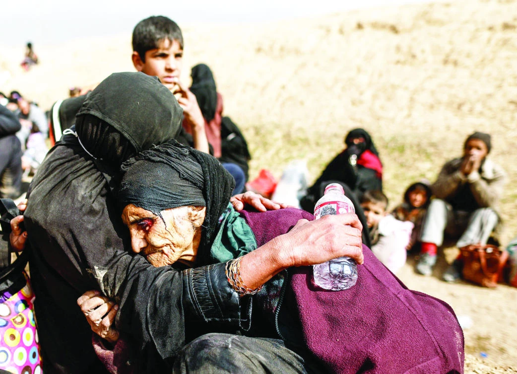 Khatla Ali Abdullah, 90, is helped by her family after they fled Mosul violence. (Reuters)