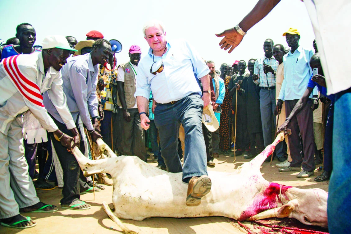 Stephen O’Brien, UN undersecretary-general for humanitarian affairs and emergency relief coordinator, jumps over a slaughtered cow in Ganyiel, South Sudan. South Sudan has been declared the site of the world’s first famine in six years, affecting about 100,000 people. (AFP)