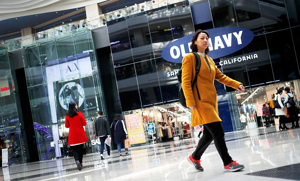 In this March 2, 2017 photo, people walk near foreign brands fashion outlets at a shopping mall in Beijing. (AP)