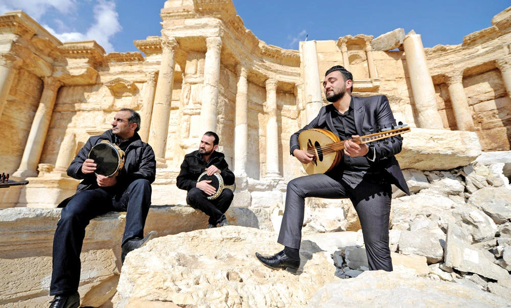 Syrian musicians play their instruments while resting on damage in the amphitheater of the historic city of Palmyra, Syria. (Reuters)