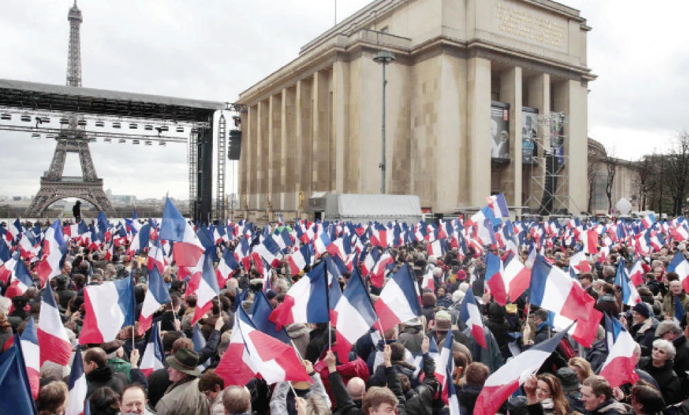 People wave national flags during a rally to support French presidential candidate Francois Fillon in Paris on Sunday. (AFP)