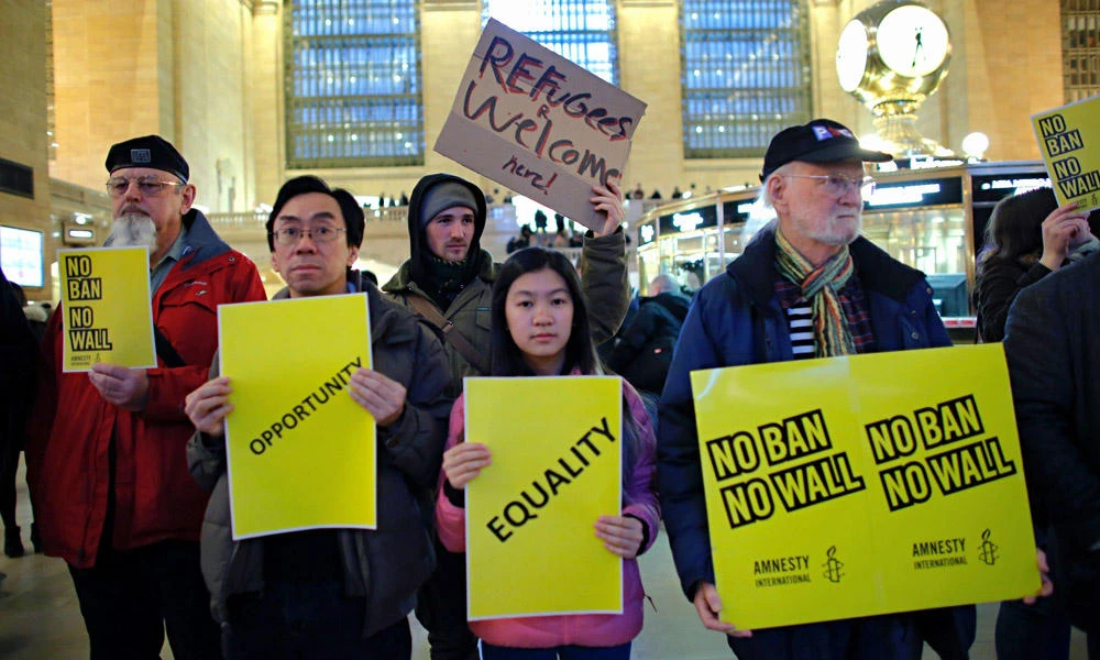 People stand holding placards as they take part in a protest called 'No Ban! No Wall! Get Loud' hosted by Amnesty International USA inside Grand Central Station on March 3, 2017 in New York City. (AFP / KENA BETANCUR)