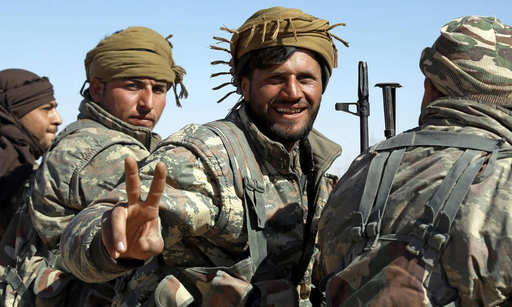 A member of the US-backed Syrian Democratic Forces (SDF), made up of an alliance of Arab and Kurdish fighters, flashes the sign for victory in the village of Sabah al-Khayr on the northern outskirts of Deir Ezzor as they advance to encircle the Daesh group bastion of Raqqa on February 21, 2017. The SDF on Monday cut off a key supply route between Raqqa and Deir Ezzor. (AFP / DELIL SOULEIMAN)