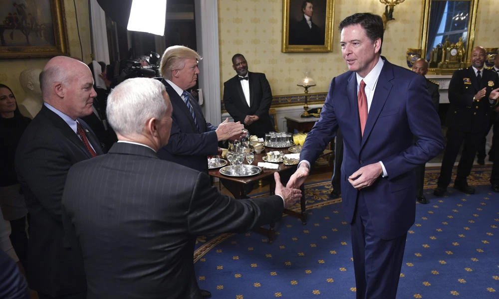 This file photo taken on January 22, 2017 shows US Vice President Mike Pence (2nd L) shaking hands with FBI Director James Comey (R) watched by Secret Service Director Joseph Clancy (L) and US President Donald Trump (3rd R) during the reception for law enforcement officers and first responders in the Blue Room of the White House in Washington, D.C. (AFP / MANDEL NGAN)