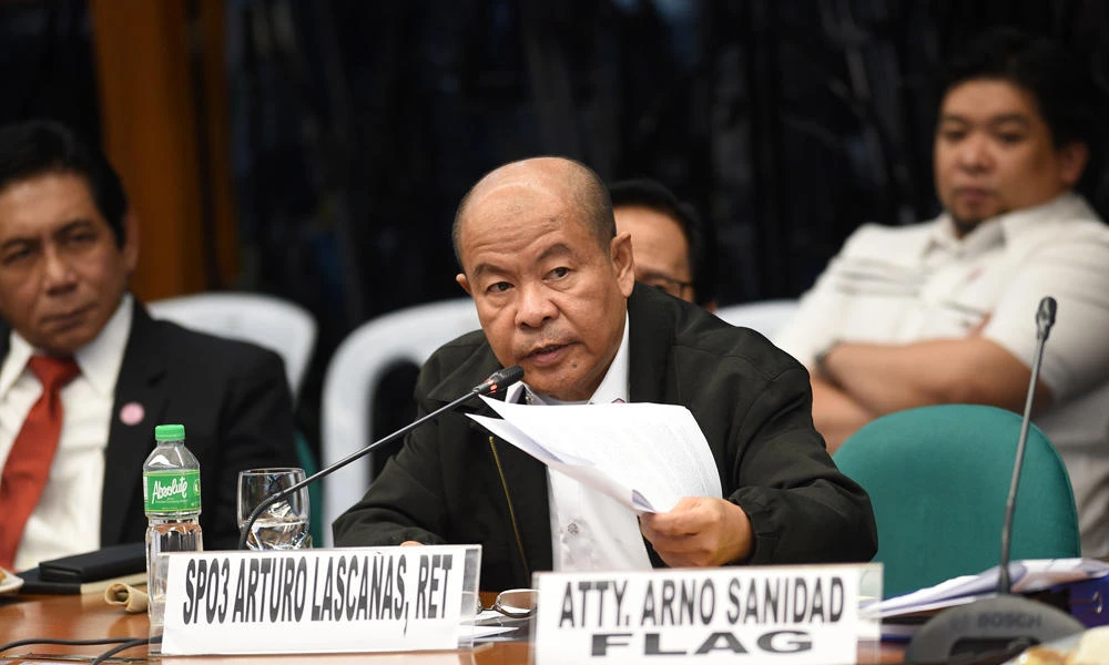 Retired police officer Arturo "Arthur" Lascanas (C) holds some documents as he testifies at a Senate hearing in Manila on Monday. The former police aide of Philippine President Rodrigo Duterte said he was part of a "death squad" that took part in over 300 killings when Duterte was a city mayor. (AFP / TED ALJIBE)