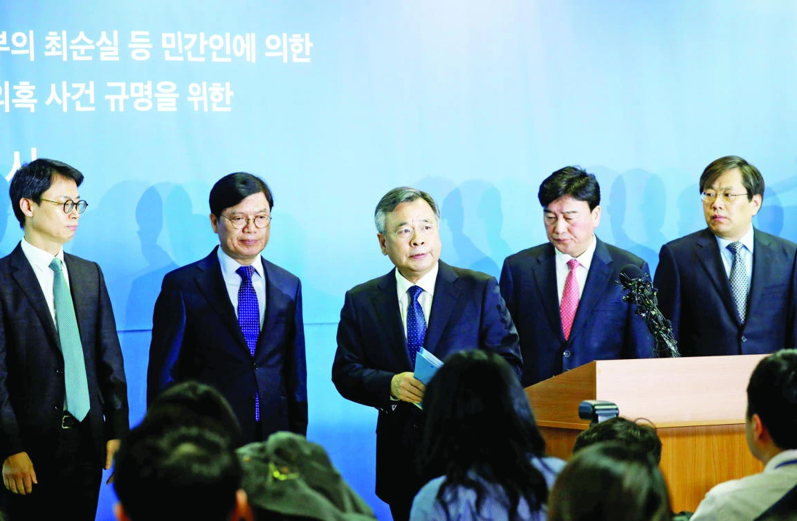 Special prosecutor Park Young-soo, center, leaves after announcing the results of their investigation over an influence-peddling scandal involving South Korean President Park Geun-hye, in Seoul, on Monday. (Reuters)