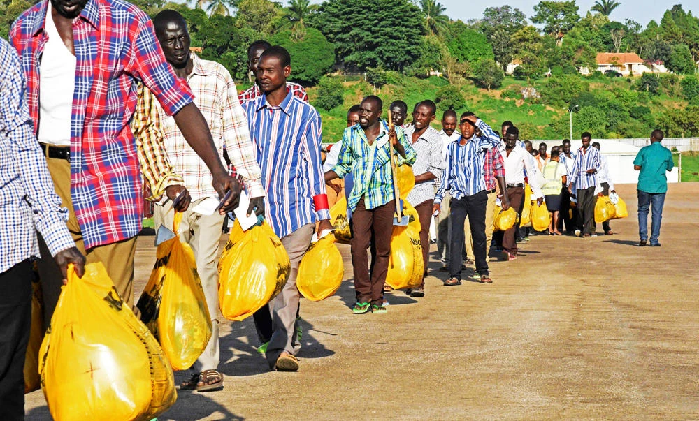 Prisoners of war from the forces of the Sudanese ruling National Congress Party walk towards an Ethiopian airplane on Sunday, in Entebbe, to be taken back home after they were released by the Sudan People's Liberation Movement-North (SPLM-N). (AFP)