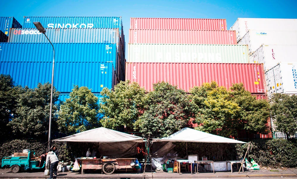A man sets up a portable food stall next to containers organised in stacks at the Shanghai Waigaoqiao Free Trade Zone in Shanghai, in this March 6, 2017 photo. (AFP)