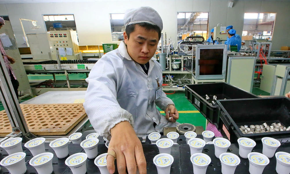 This picture taken on February 28, 2017 shows a Chinese employee working on an energy-saving bulb production line at a lighting factory in Suining, southwest China's Sichuan province. (AFP)