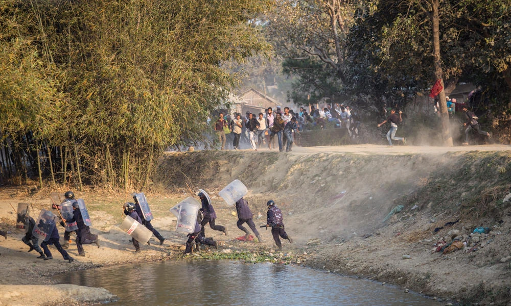 Nepalese riot police run for cover as Madhesi activists hurl stones at them in Saptari District, Nepal, on March 6, 2017. (REUTERS/Shreedhar Poudel)