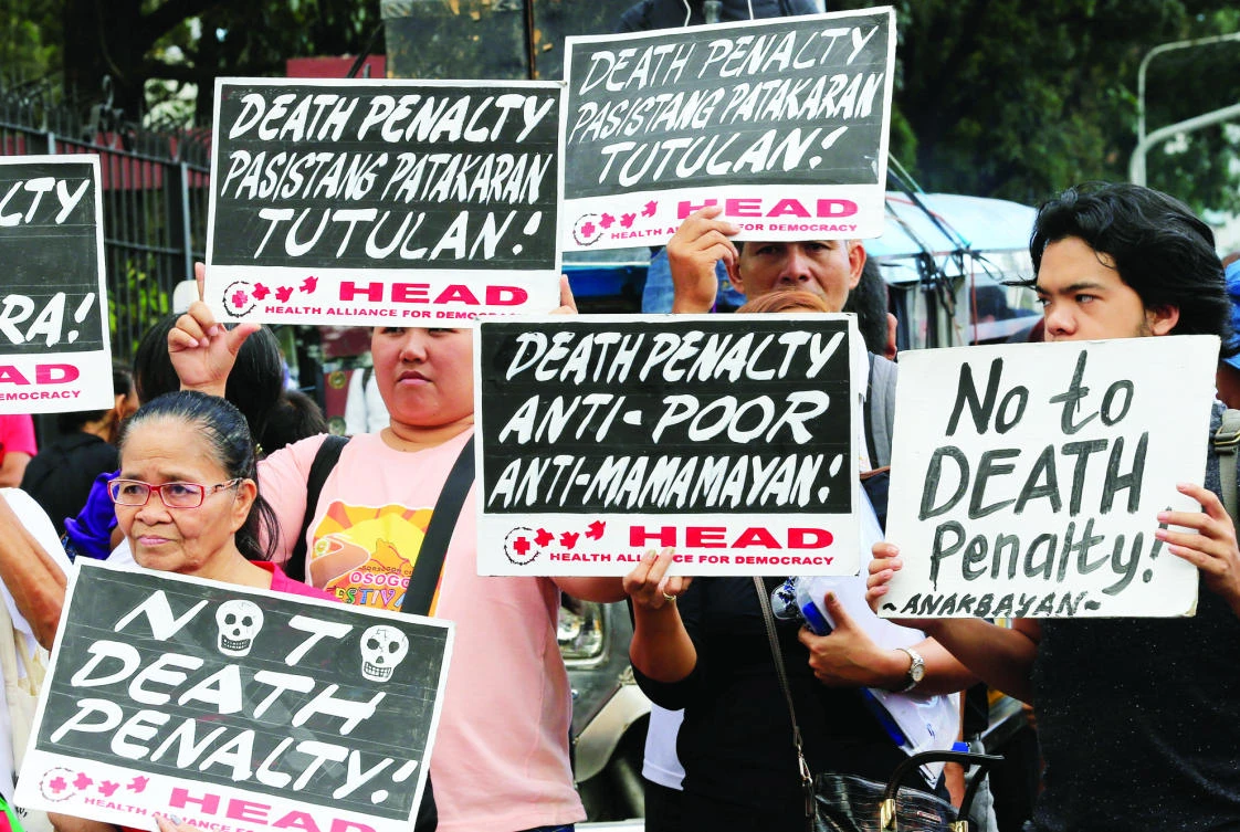 Activists hold placards during a protest rally against the passing of the death penalty bill, at the gate of House of the Representatives in Quezon city, metro Manila, on Tuesday. (Reuters)